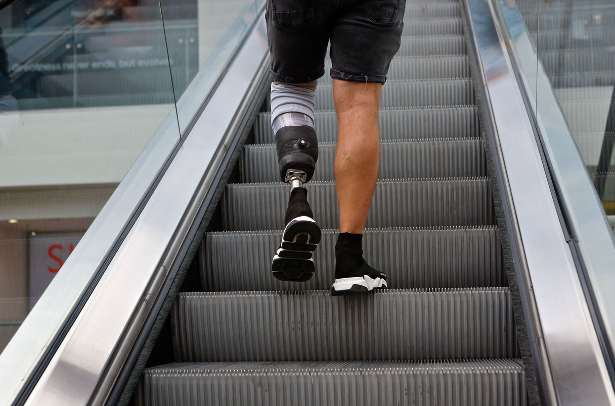 London (UK), 6 July 2021: A man with a prosthetic leg negates an escalator in central London shopping centre